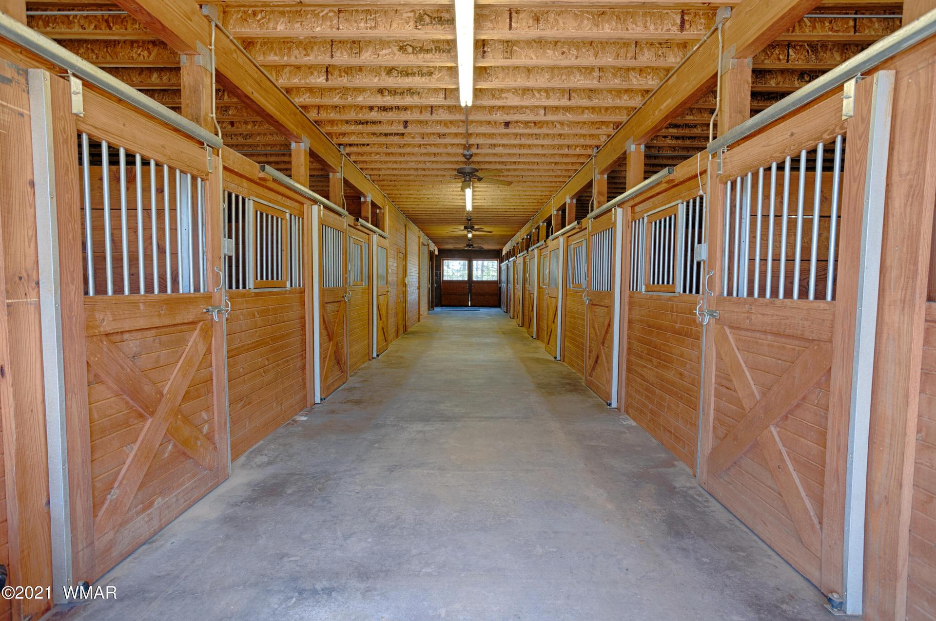 Interior of a wooden barn featuring horse stables